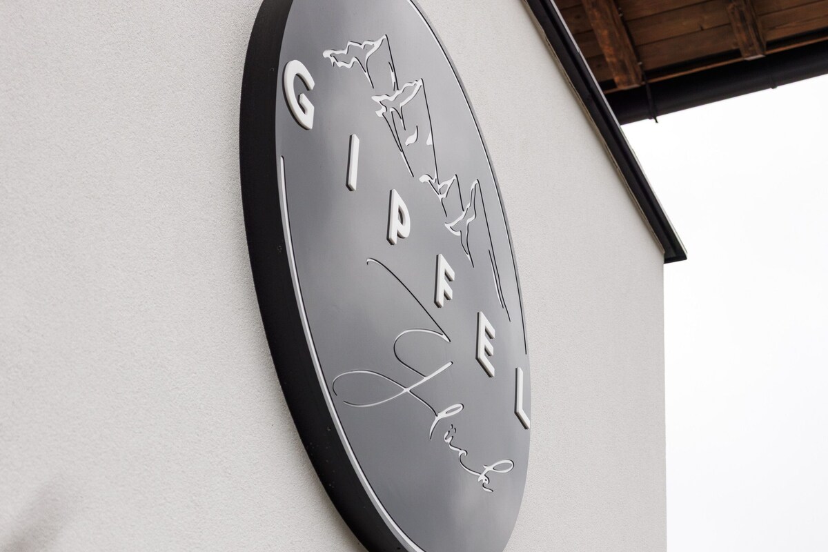 A circular sign with the words "GIPFEL" and "Hotel" on a building facade.
