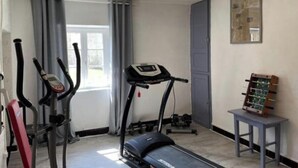 Un gimnasio en casa con cintas de correr, elípticas y una bicicleta estática.