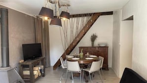 Una sala moderna con chimenea, comedor y escalera.