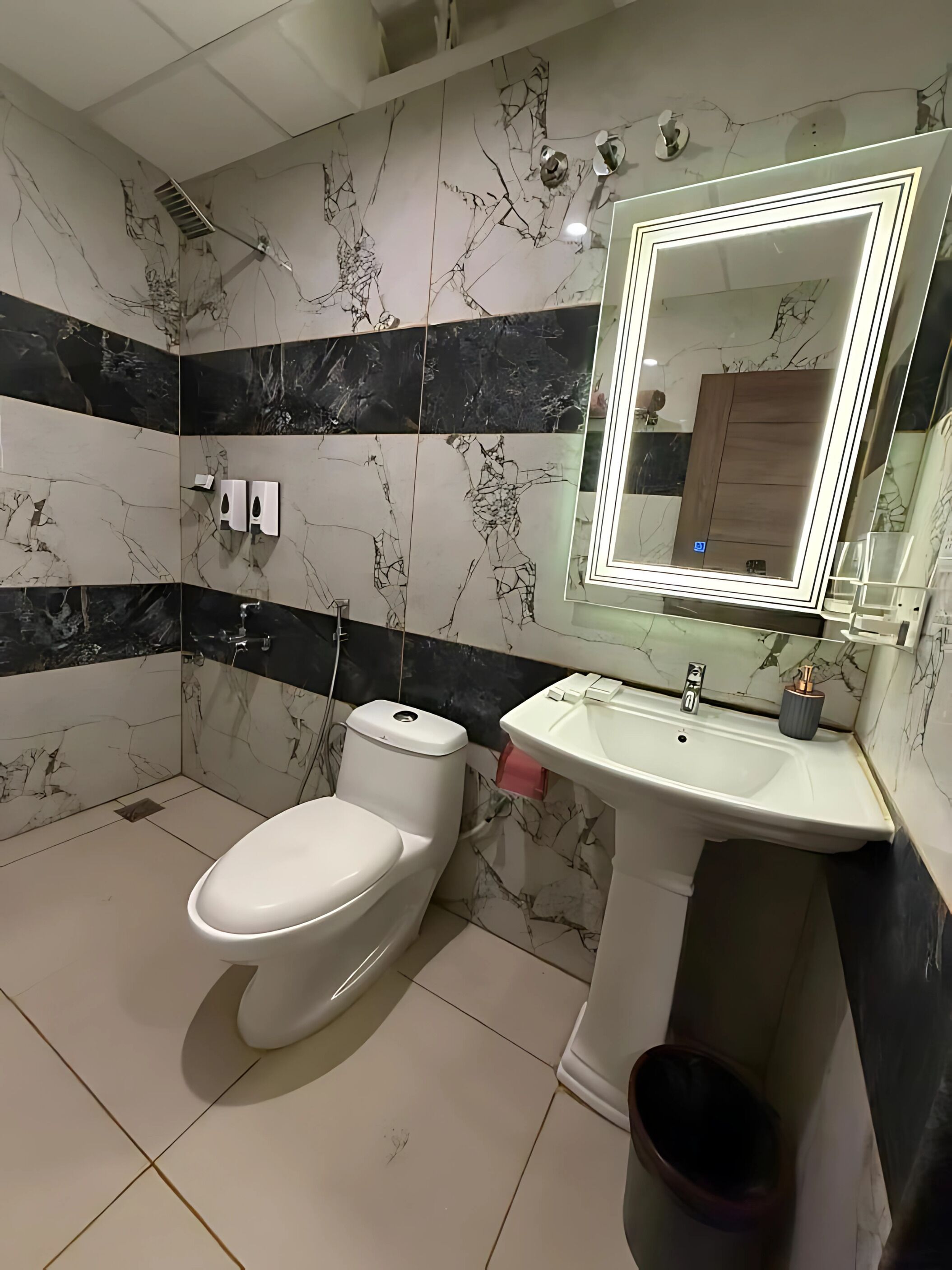 A bathroom with a toilet, sink, and mirror.