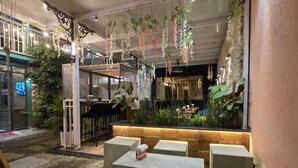 Een binnenzitgedeelte met betonnen banken, hangplanten en een bar.