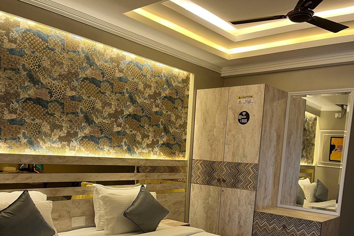 A modern bedroom with a large bed, a ceiling fan, and a decorative wall panel.