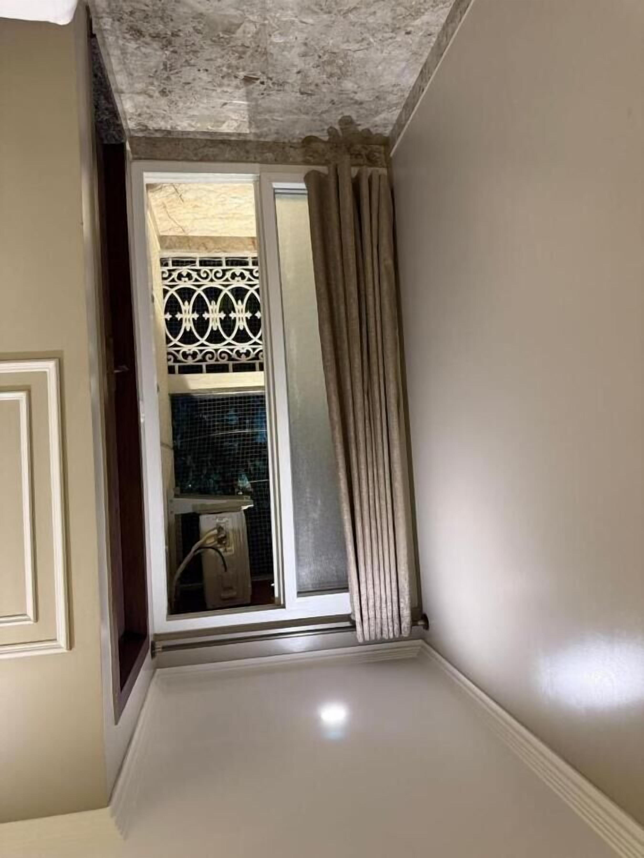 A room with a sliding glass door leading to a balcony, a tiled backsplash, and a white door.