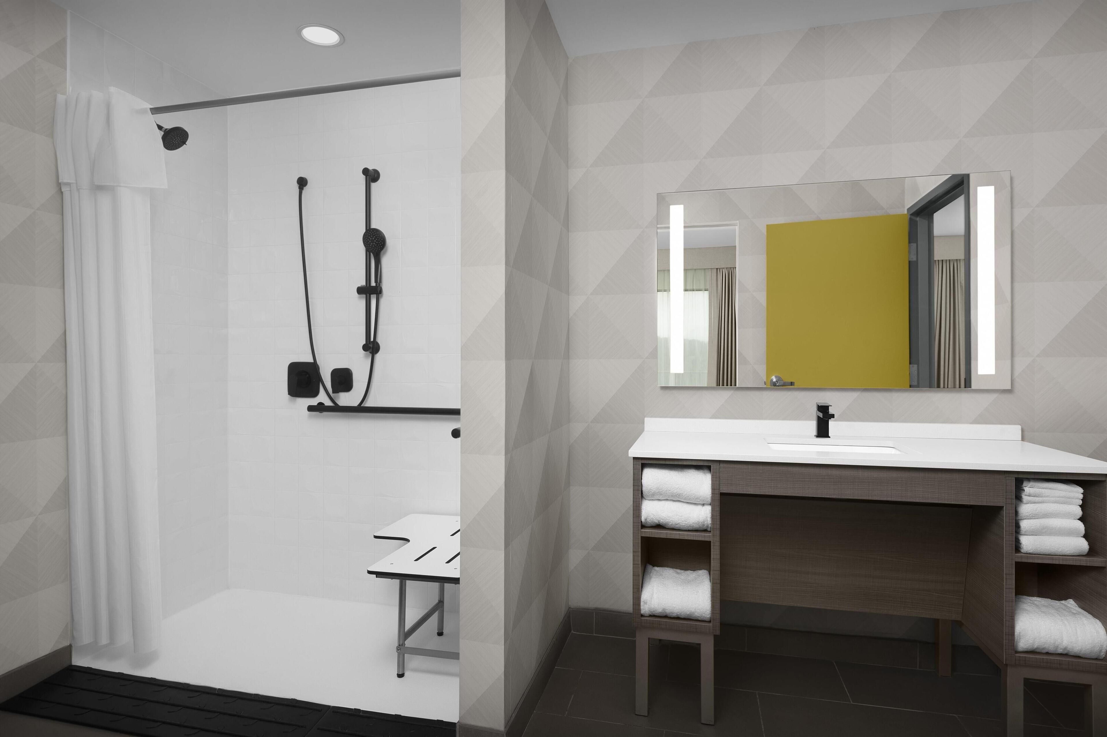 A modern bathroom with a shower, a sink, and a mirror.