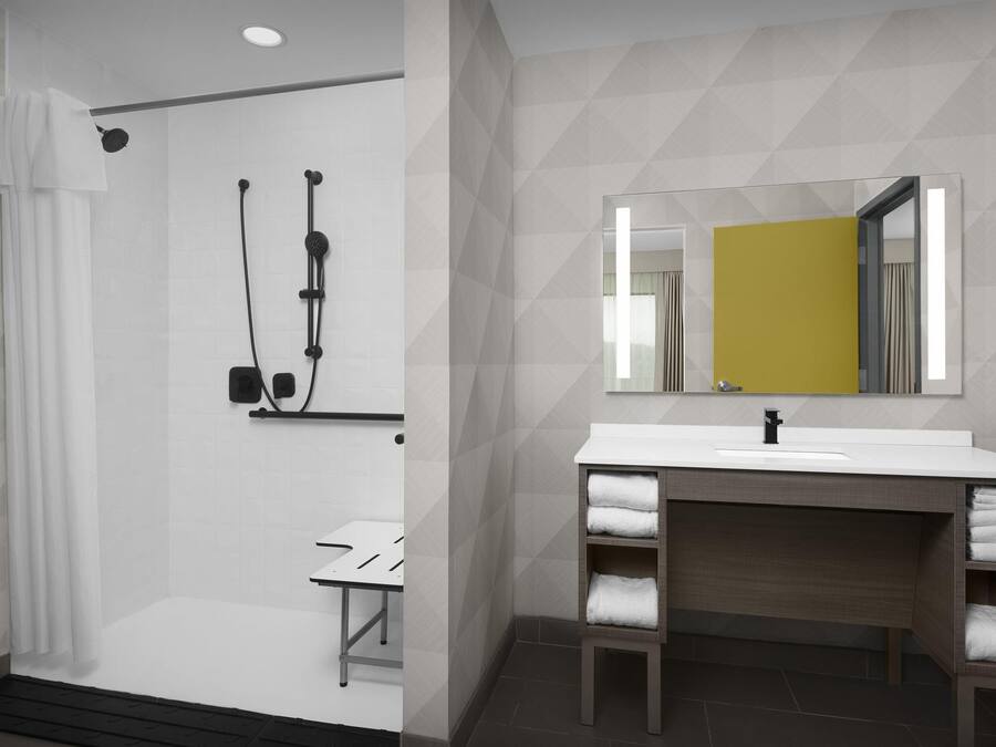A modern bathroom with a shower, a sink, and a mirror.
