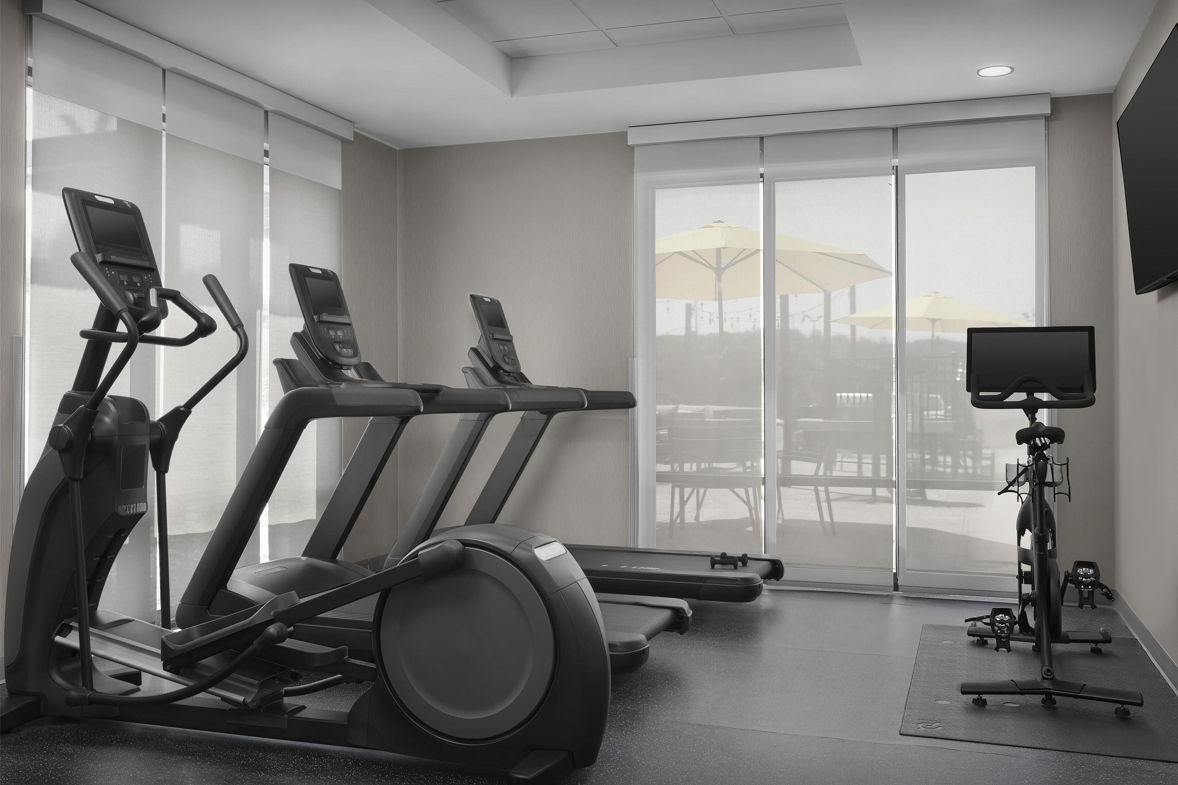 A gym with treadmills, an elliptical, and a stationary bike.