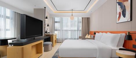 A modern hotel room with a large bed, a flat-screen TV, a desk, and a large window.