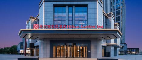 A modern hotel with a prominent entrance and signage.