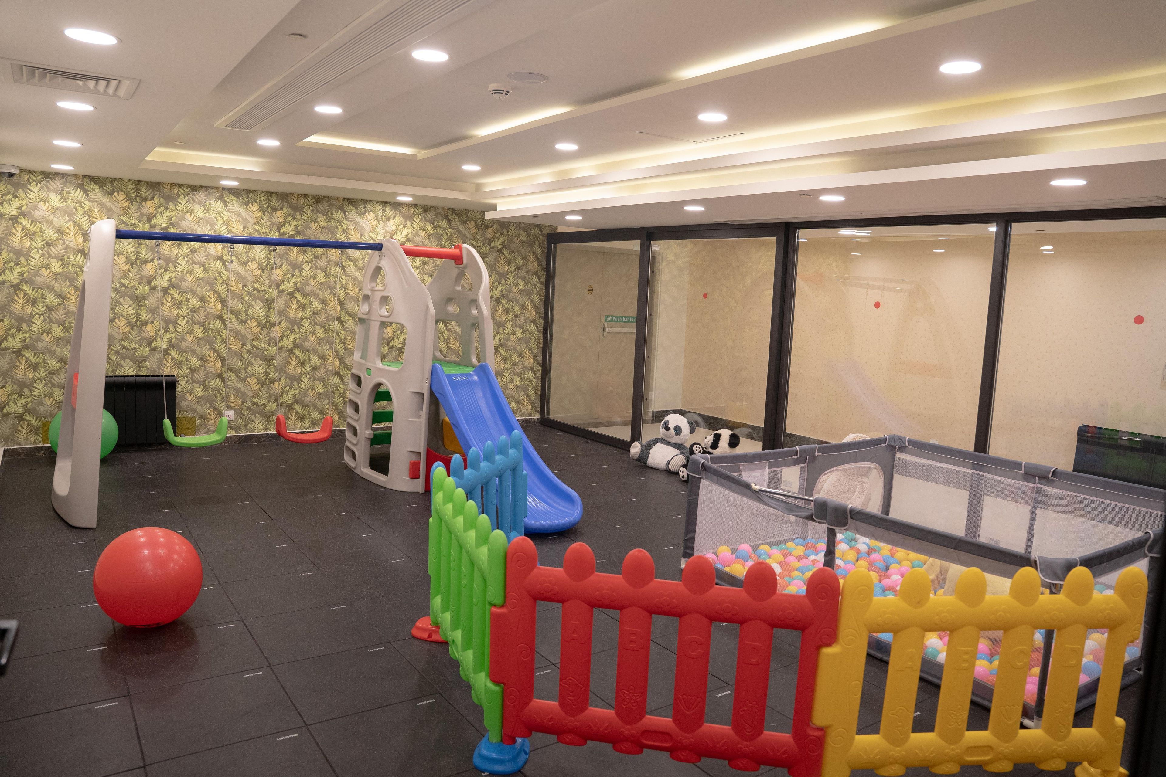 A play area with a slide, climbing structures, and a ball pit.