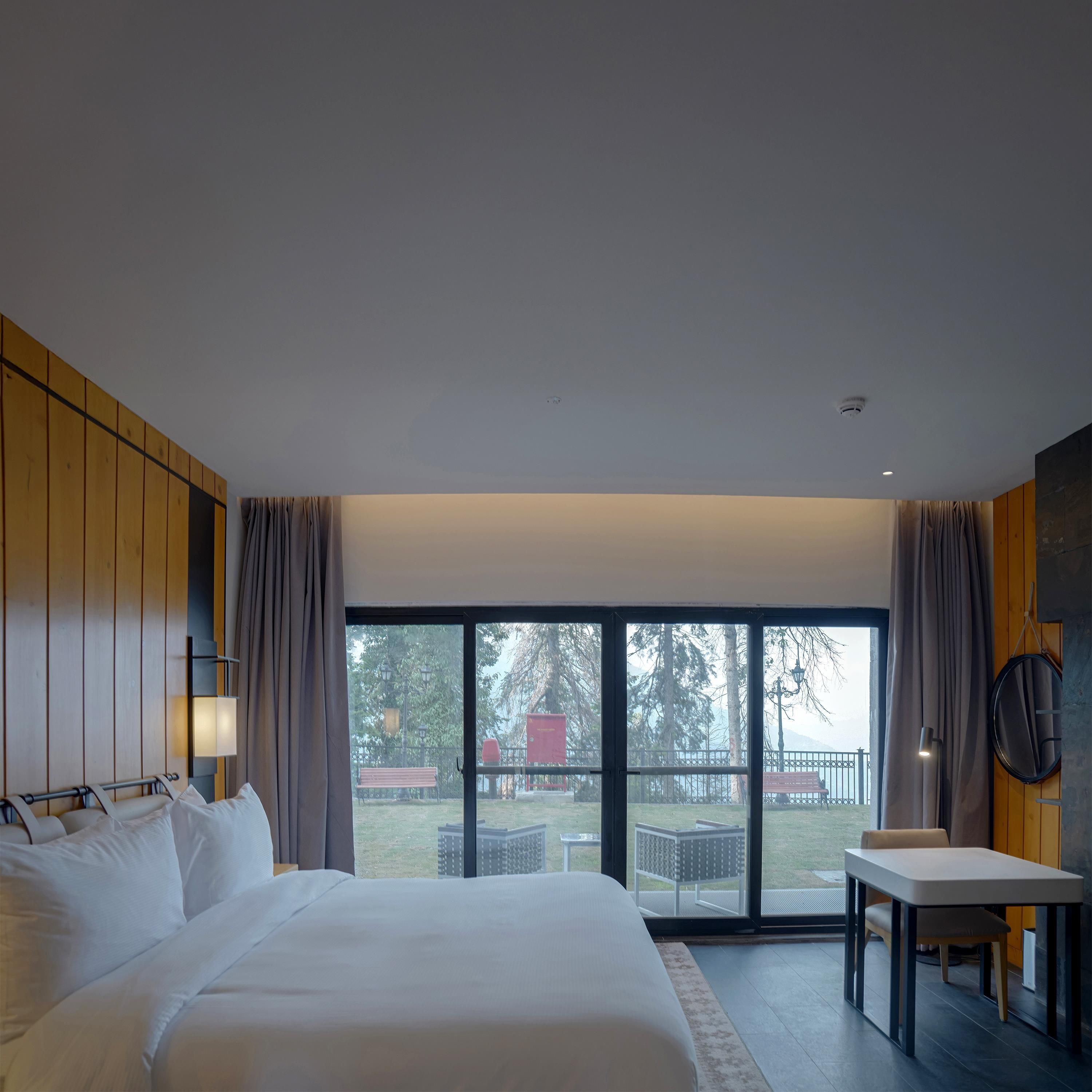 Une chambre d’hôtel avec un grand lit, une table à manger et une vue sur l’extérieur.
