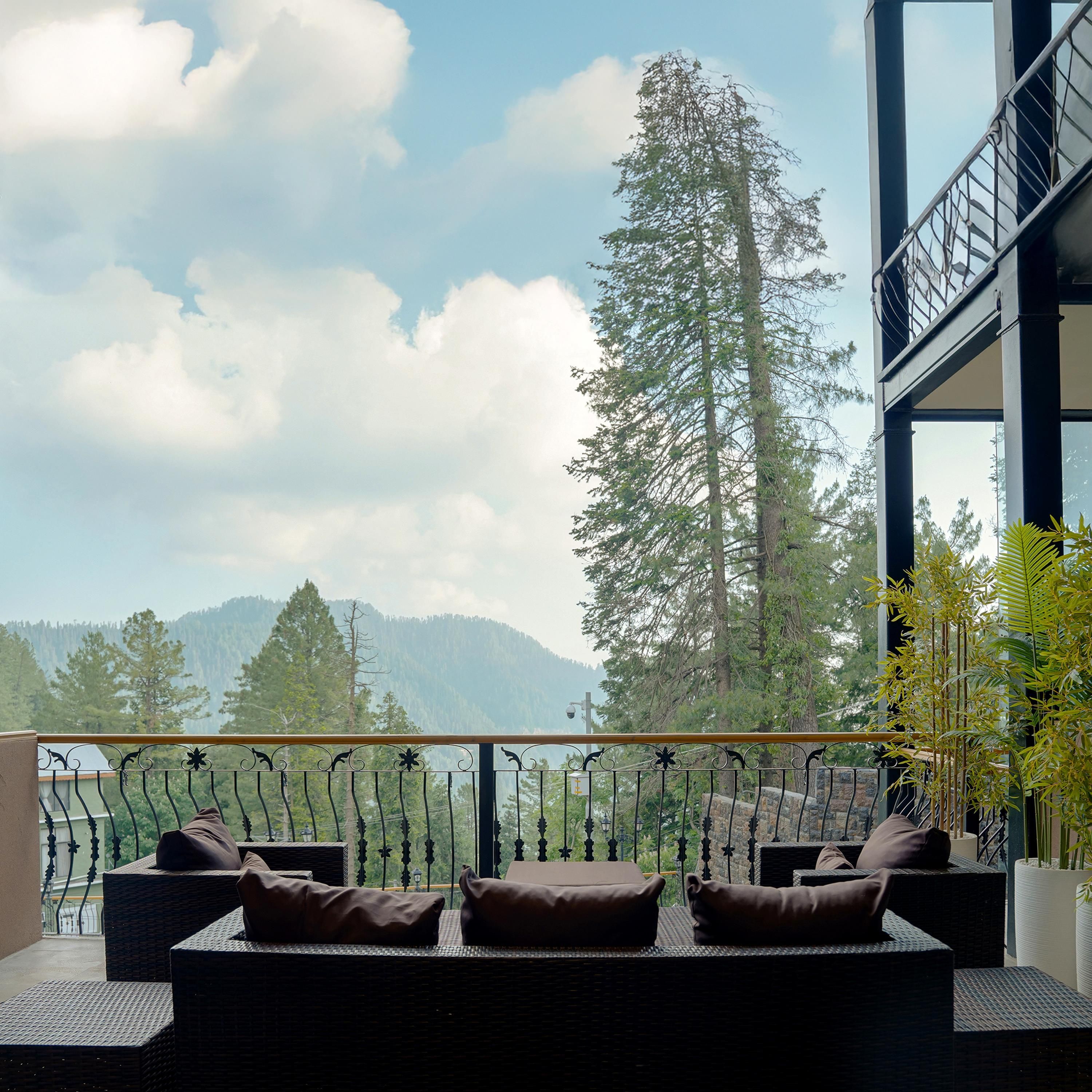 A balcony with wicker furniture and a view of mountains.