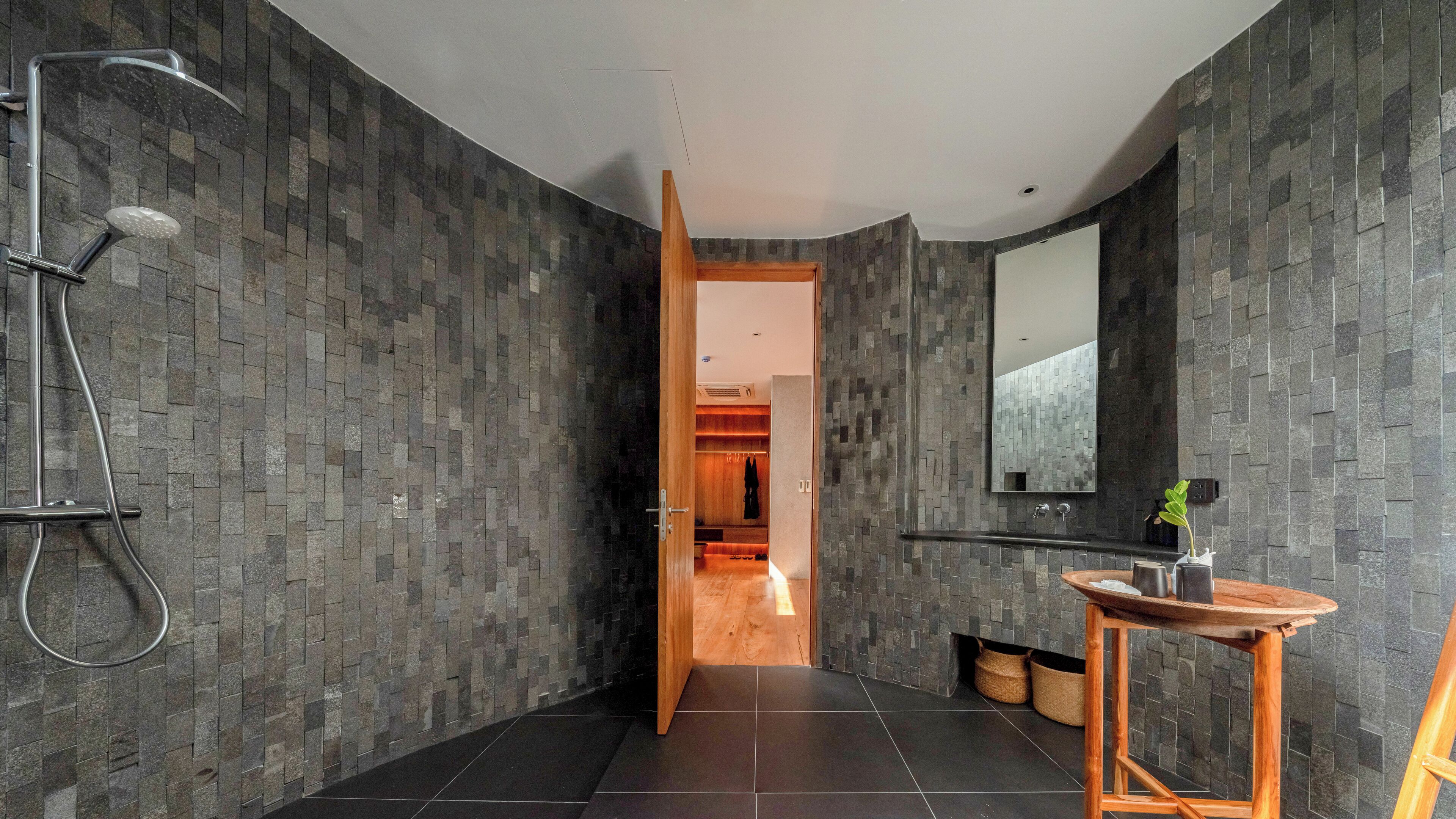 Een moderne badkamer met een douche, wastafel en spiegel.