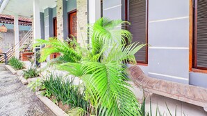 A building with a covered porch, stone pillars, and a bench. - Collection O Sanur Near Bali Exotic Marine Park (Denpasar)