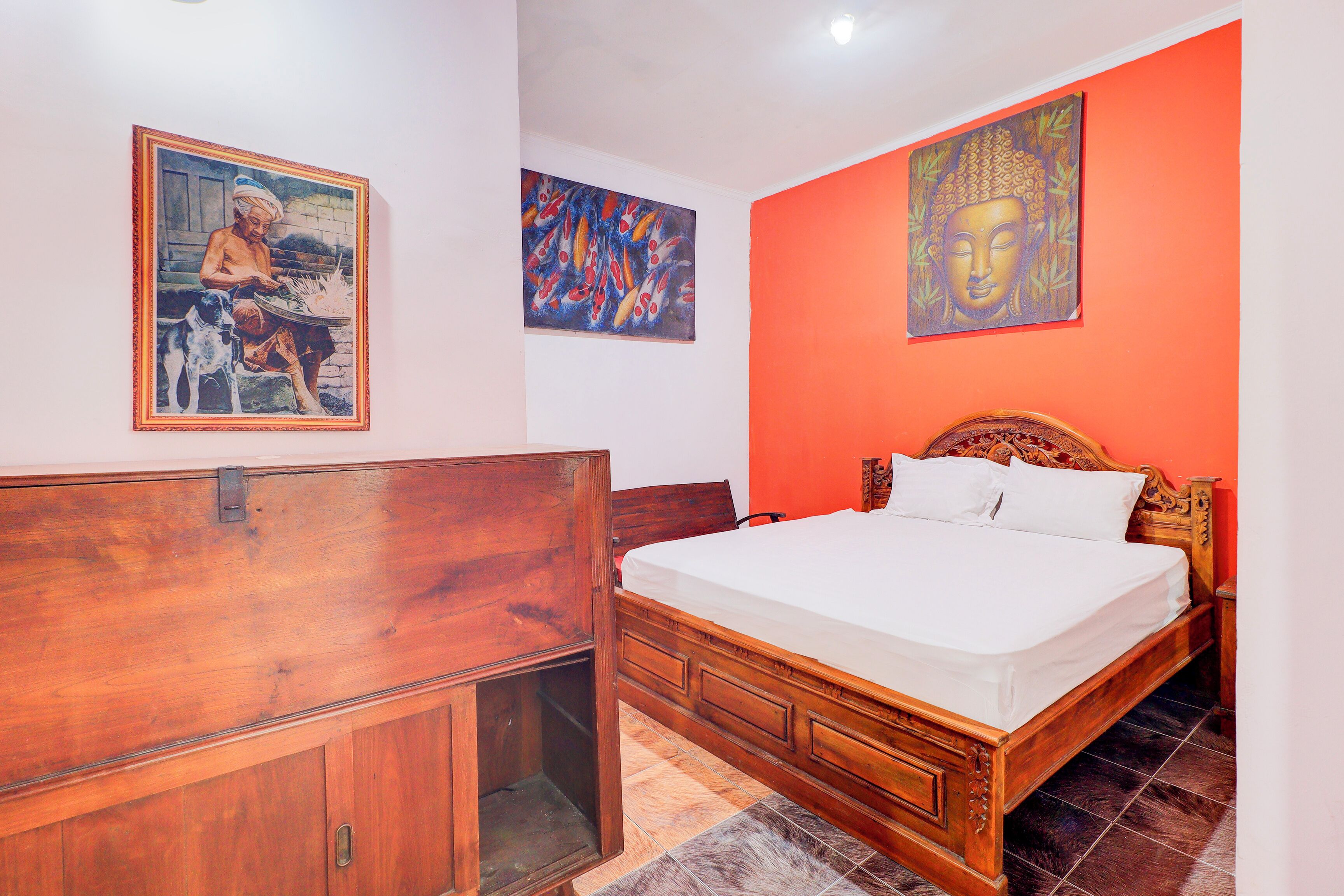 A bedroom with a wooden bed, a wooden wardrobe, and two paintings on the walls.