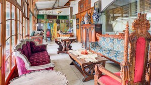 A traditional room with wooden furniture, a large window, and a ceiling fan. - Collection O Sanur Near Bali Exotic Marine Park (Denpasar)