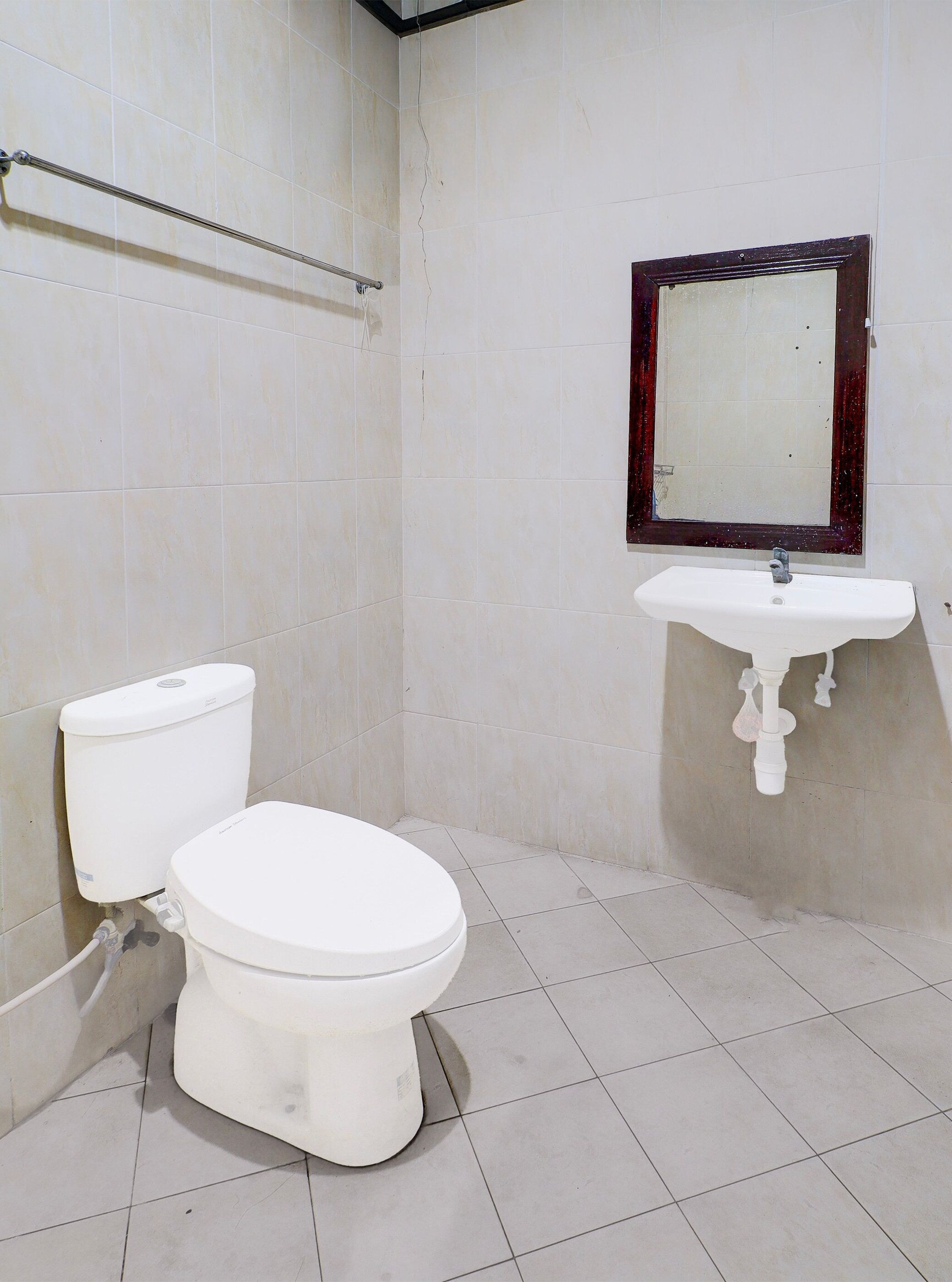 A bathroom with a toilet, a sink, and a mirror.