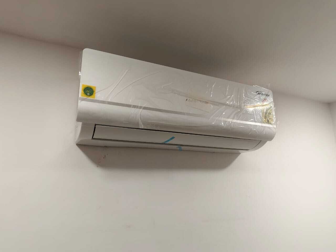 A white air conditioning unit mounted on a plain wall.