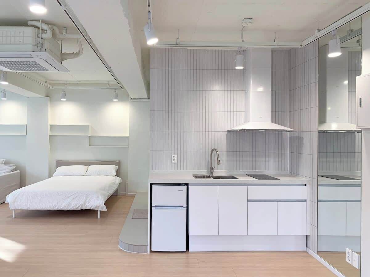 A modern kitchen with a built-in dishwasher, a sink, and a large window.