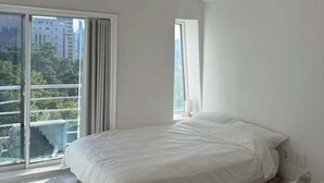 Une chambre à coucher avec un grand lit, un canapé et deux lampes suspendues.