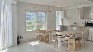 Une cuisine moderne avec un coin repas, de grandes fenêtres et une vue sur la ville.