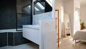 A modern bathroom with a glass shower enclosure, a white vanity, and a skylight. - Charming house - near train station - 6 people (Les Sables-d´Olonne)