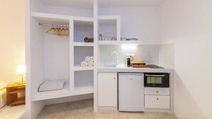 A compact kitchen with built-in storage, a refrigerator, a microwave, and a sink. - Blu Dot Tinos by TinosHost (Tinos)
