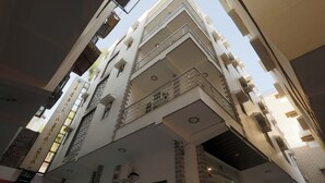 Un edificio de varios pisos con un diseño arquitectónico moderno, con balcones y ventanas amplias.