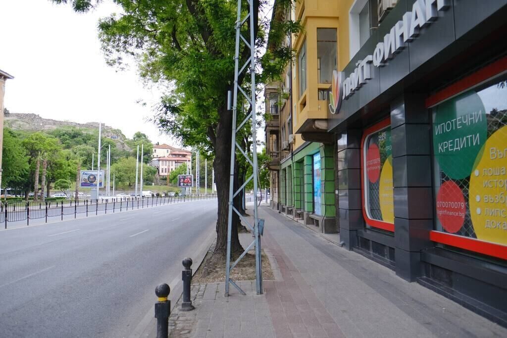 Une vue de rue avec un immeuble sur lequel est affichée une grande publicité pour des services de crédit.