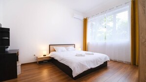 A bedroom with a bed, bedside table, and a desk. - Apartment in the city center (Plovdiv)