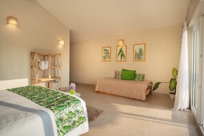 A bedroom with a bed, a wooden chair, a small table, and a potted plant. - Green Leaf Resort (Canacona)