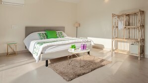 Un dormitorio con cama, mesita de noche, lámpara y un estante decorativo de madera.