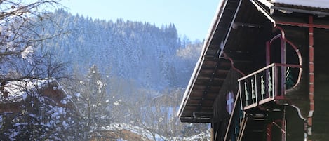 Un bâtiment en bois, avec un toit enneigé et un balcon.