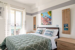 Ein Schlafzimmer mit einem Bett, einem Gemälde, einem Fenster mit Vorhängen und einem Holzschrank.