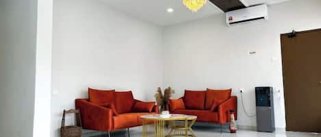 Una sala de estar moderna con un sofá, una mesa de centro y una araña.