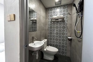 A bathroom with a sink, toilet, and shower. - mana mana hotel • Melaka • (Melaka)