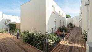 Un edificio moderno con terraza de madera y jardín.