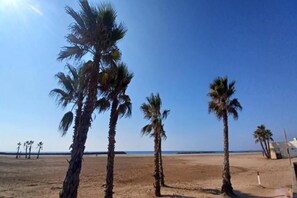 A beach with palm trees and a clear sky.