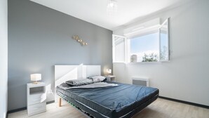 A modern bedroom with a bed, bedside tables, and a window. - Peaceful Villa in Sérignan (Sérignan)