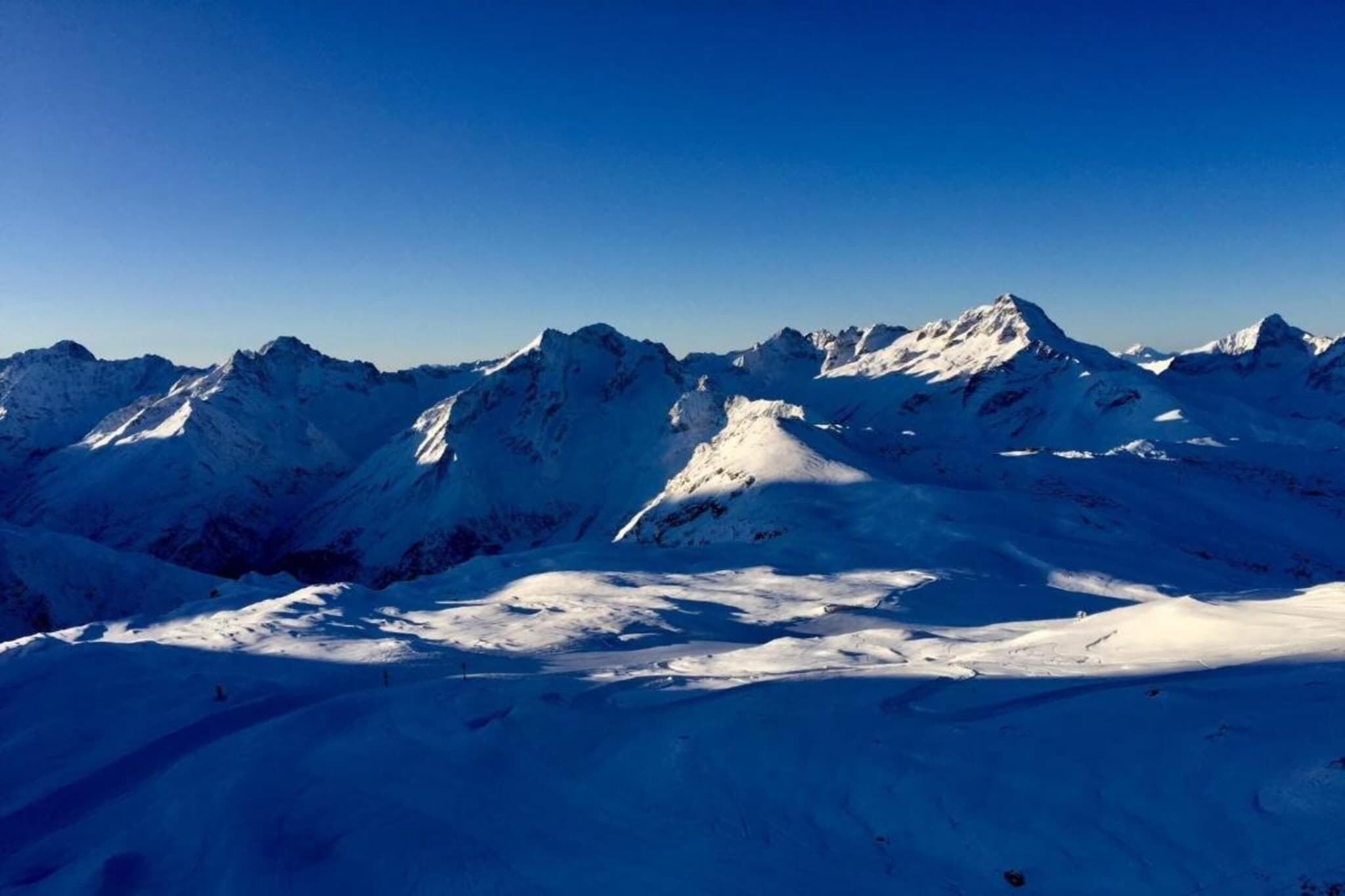 Una cadena montañosa cubierta de nieve con cielos despejados.