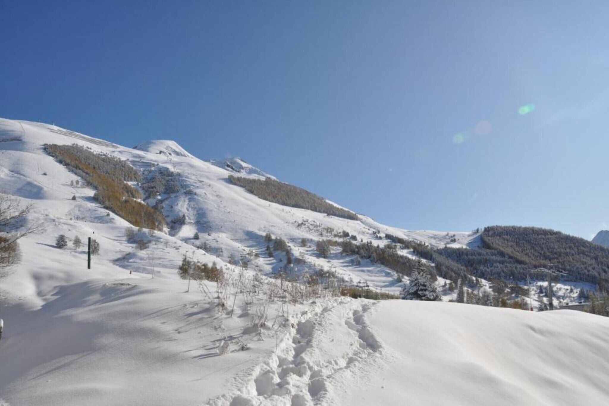 A snow-covered mountain landscape with clear skies.
