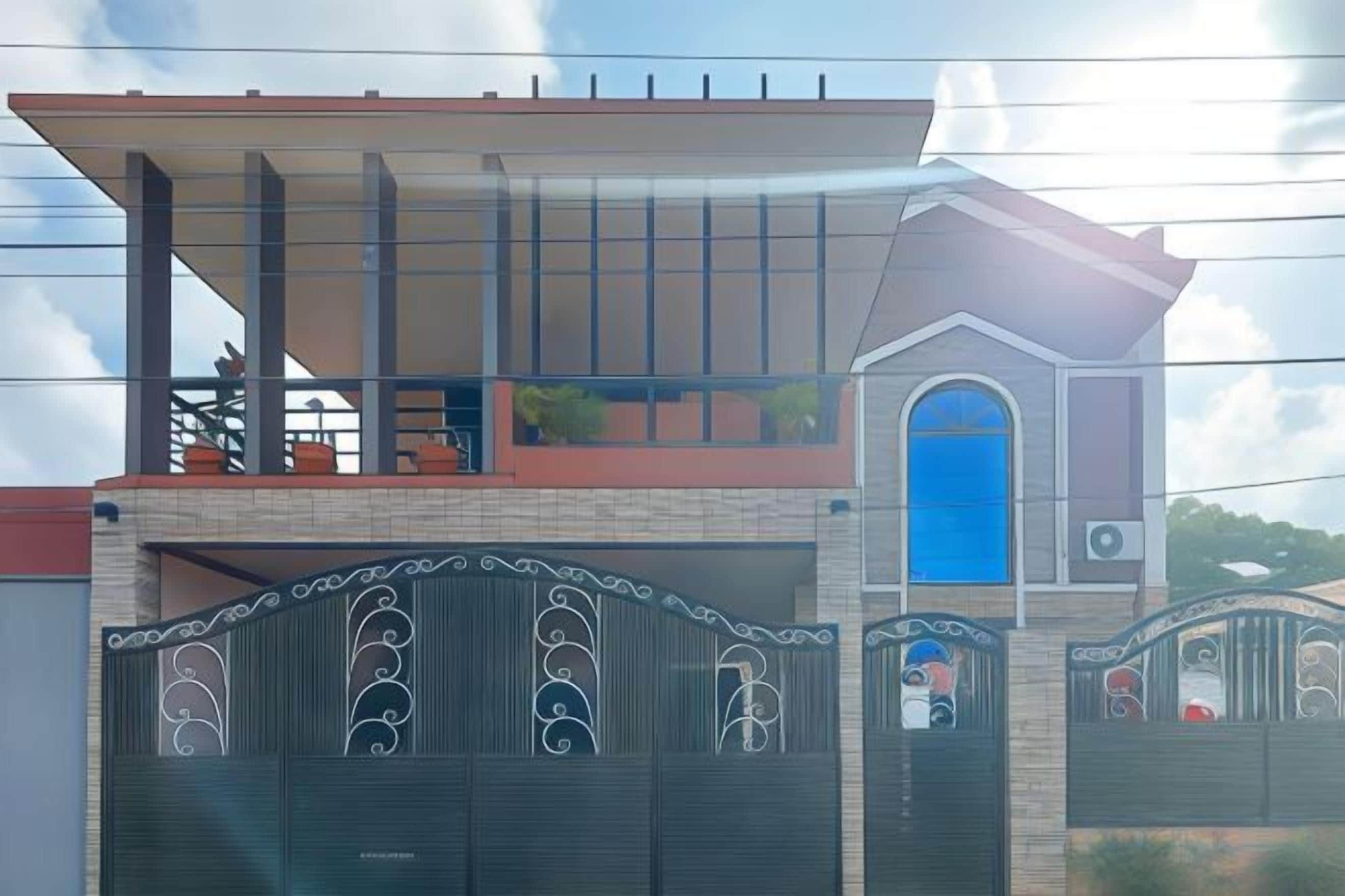 A residential building with a prominent garage door, a balcony, and a blue window.