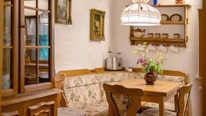 Un espace repas comprenant une table en bois, un banc et un luminaire suspendu.
