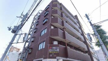 A multi-story building with a commercial sign on the ground floor.