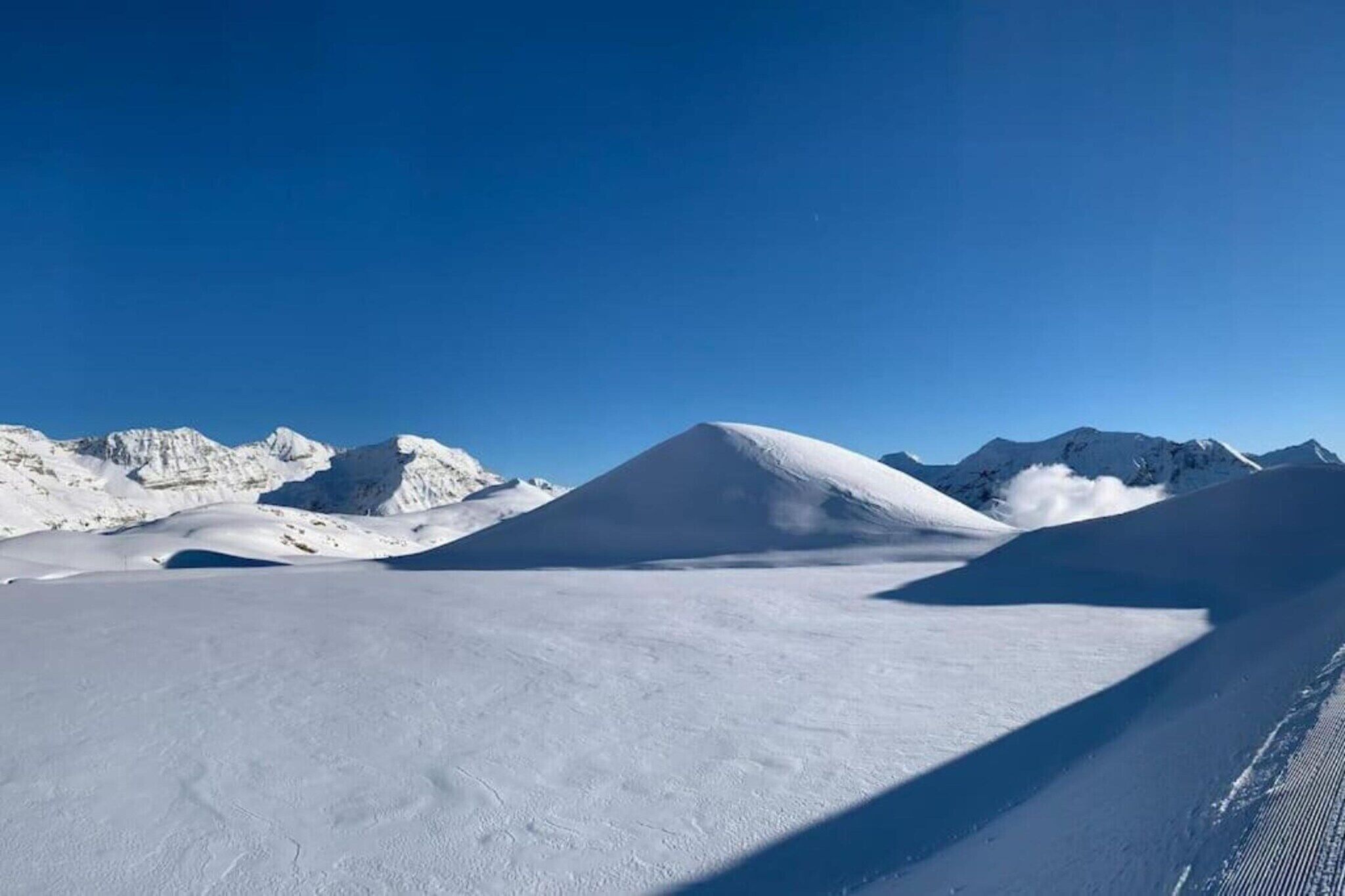 A snow-covered landscape with mountains in the background.