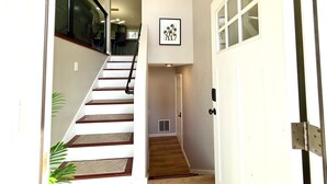 Una escalera que lleva a un rellano con una puerta a la derecha.