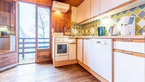 Una cucina con mobili in legno, un fornello, una lavastoviglie e uno schienale piastrellato.