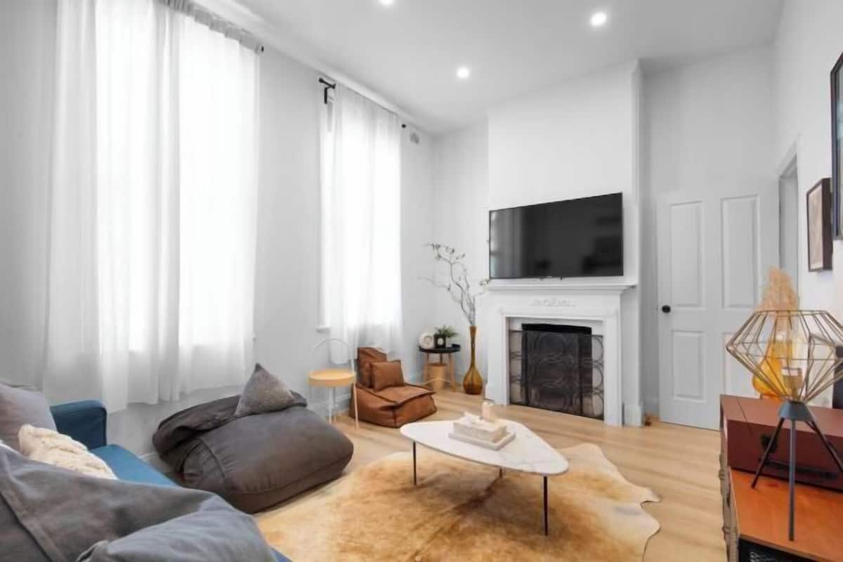 Una sala de estar moderna con chimenea, televisor de pantalla plana y sofá.
