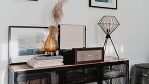 A modern living room with a large flat-screen TV, a vintage radio, and a unique geometric floor lamp.