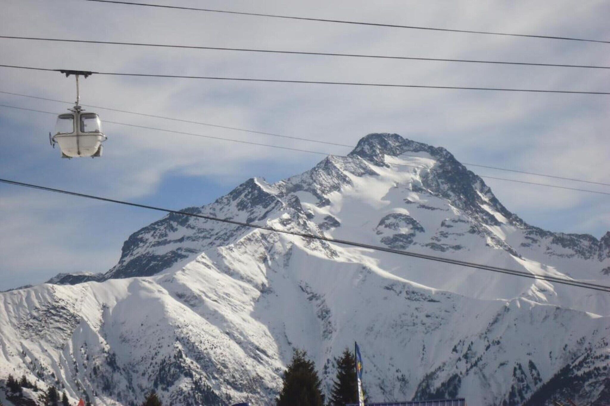 A cable car system with a snow-covered mountain in the background.