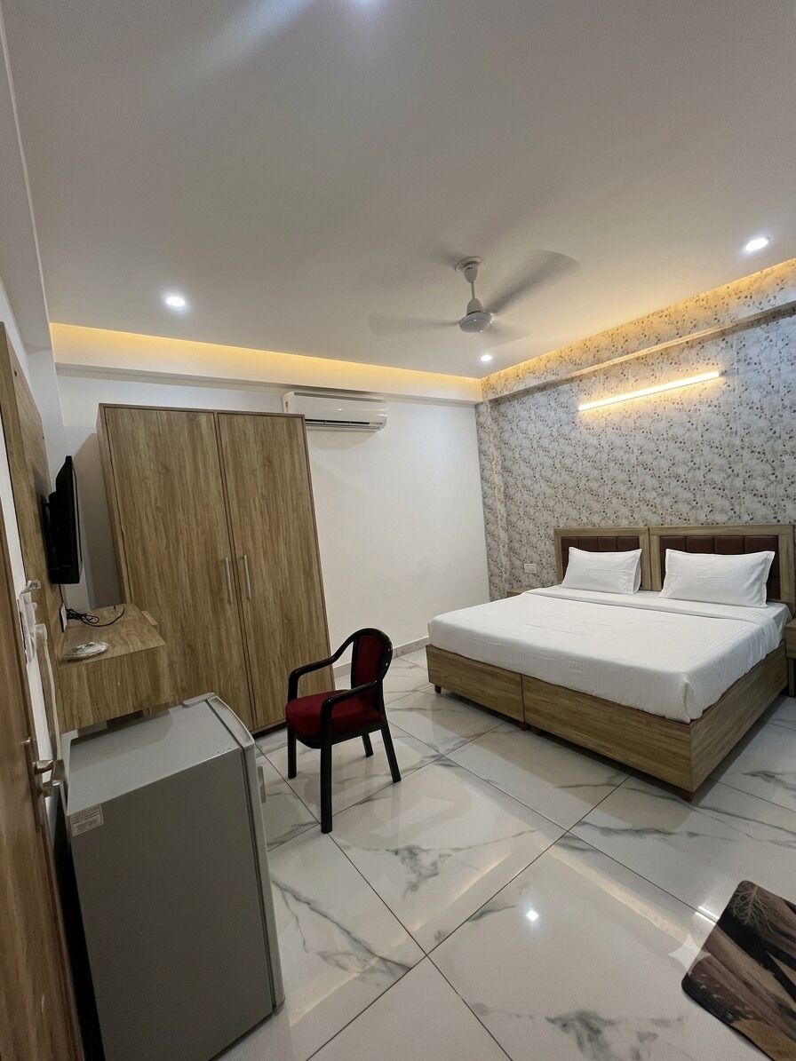 Quarto com cama, escrivaninha, cadeira, guarda-roupa e televisão.